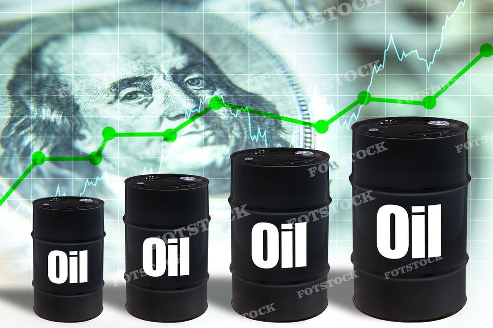 На фотографии изображены черные нефтяные бочки с белой надписью "Oil", расположенные на переднем плане. За ними виден график с зеленой восходящей линией, указывающей на рост, и размытое изображение стодолларовой купюры с портретом Бенджамина Франклина. Это изображение может использоваться для иллюстрации роста цен на нефть или экономической просперитетности, связанной с нефтяной индустрией.